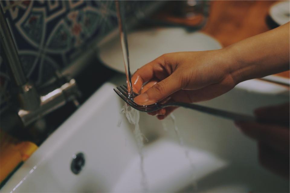 Ruce instalatéra při opravě baterie u umyvadla